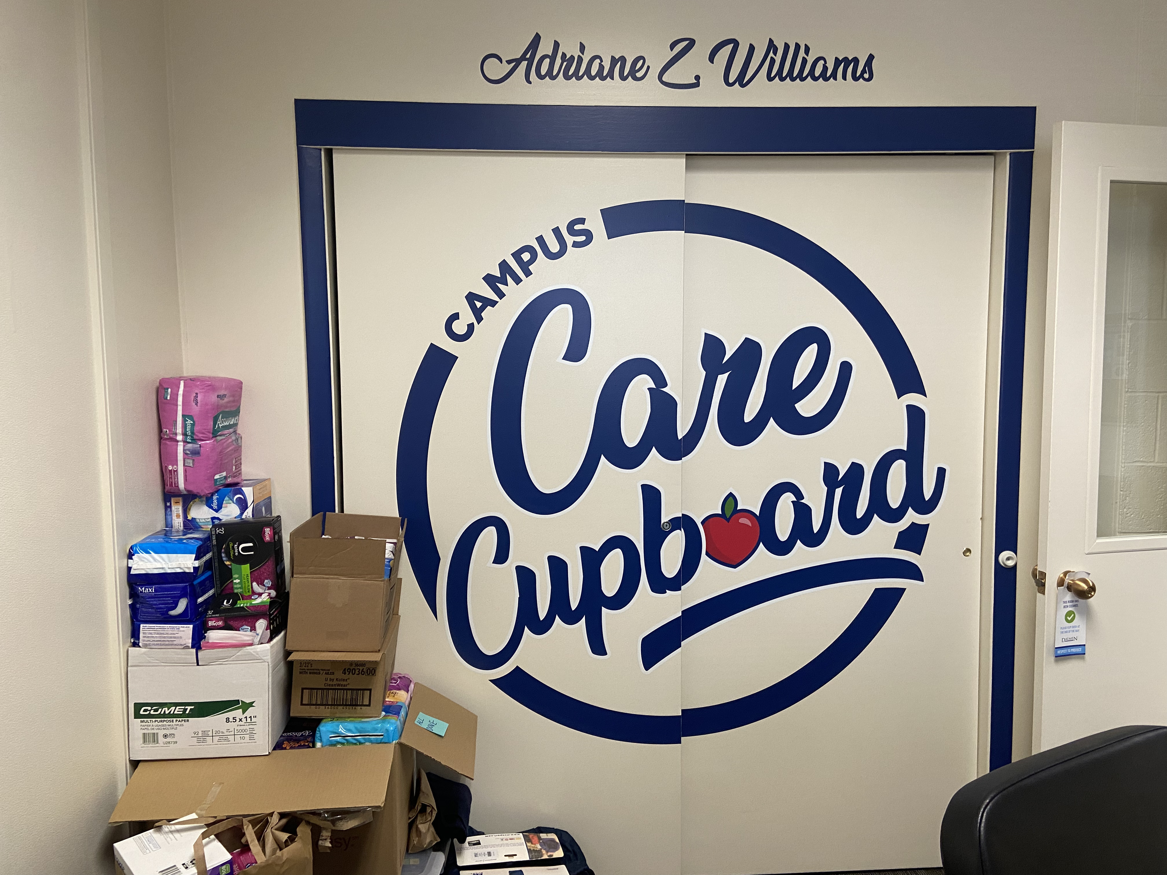A closet with a logo for the Daemen University Campus Care Cupboard.