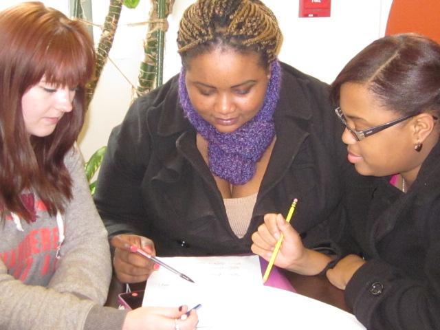 Three students sitting at a table for coaching session