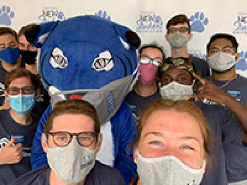 Students wearing face masks with willie the wildcat
