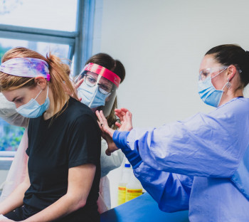 Two nursing students examining another student