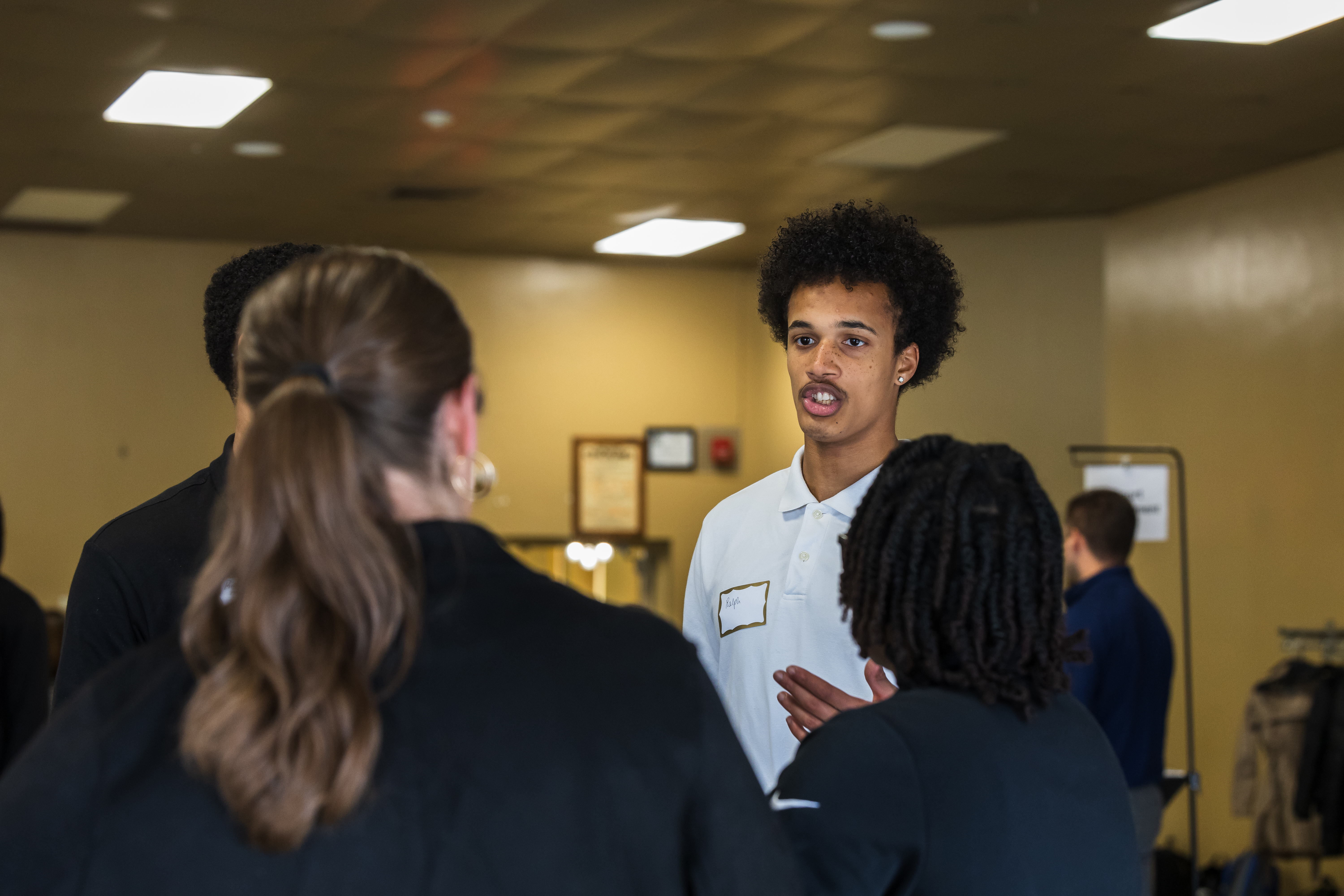 Male student talking with a group of others 