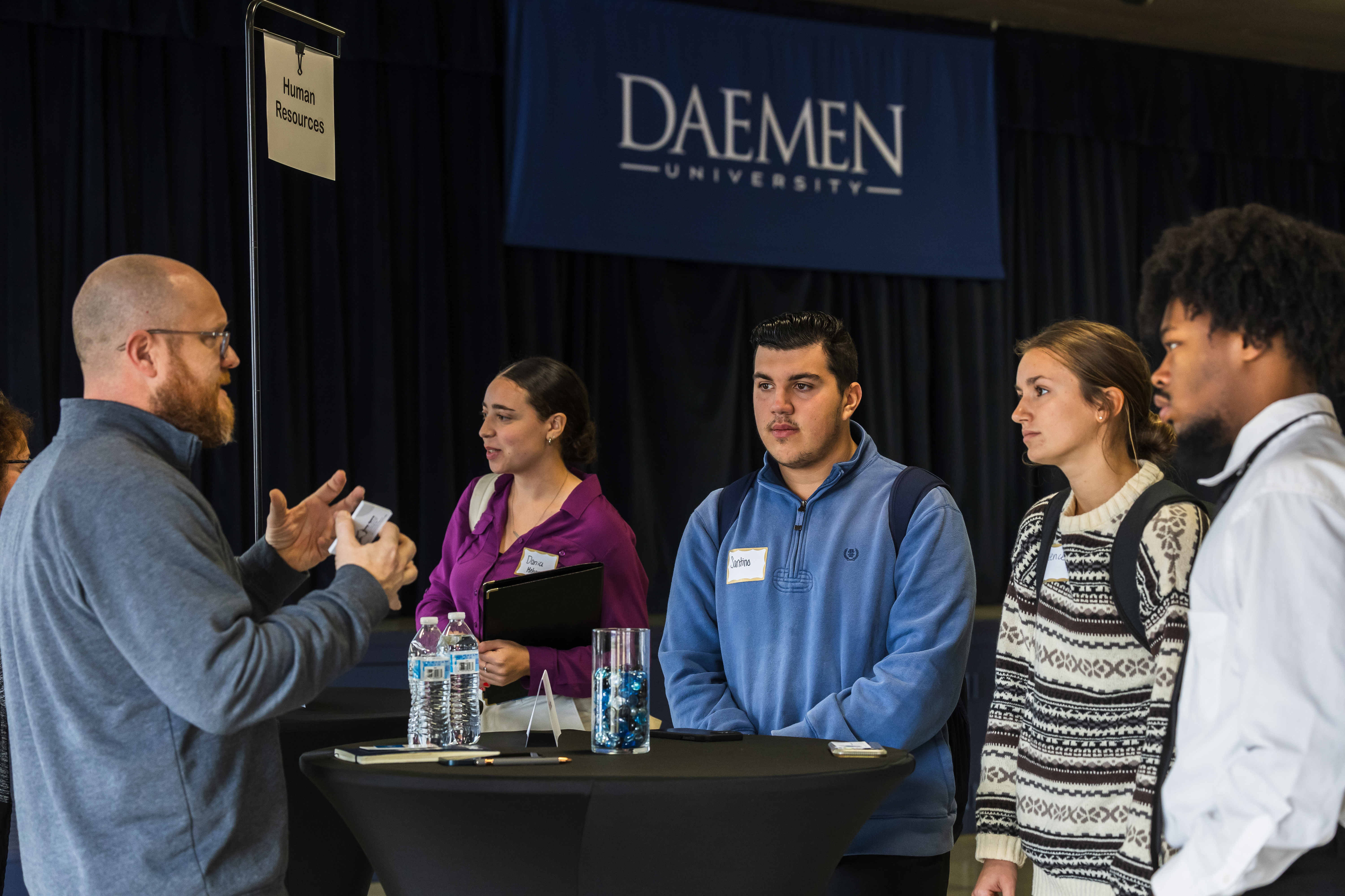 Students talking with faculty member at Human Resources table