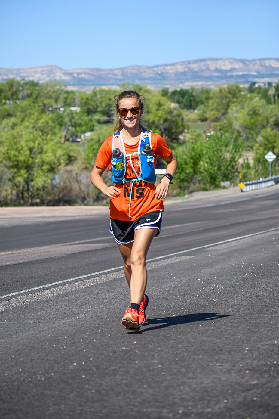 Meghan Guhler ‘16 running on road with mountains behind her