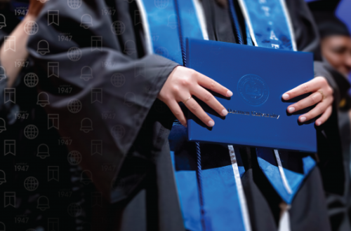 Graduating student holding diploma at commencement