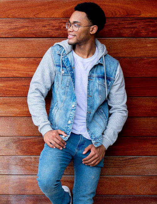 Isiah Hill-Goldsmith leaning on a wooden wall