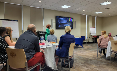 Attendees sitting at round tables listening to speaker at Leadership and Innovation event