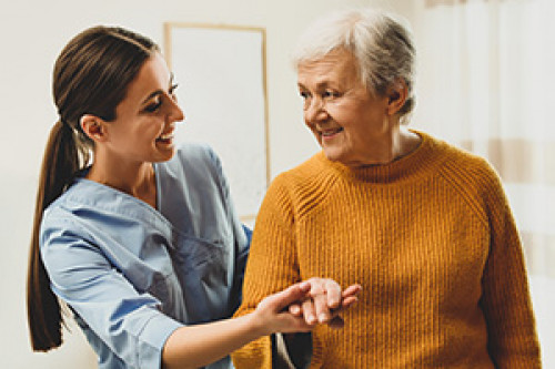 Female nurse helping an elderly female patient