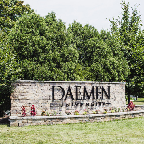 Daemen University front of campus sign; RIC visible through trees
